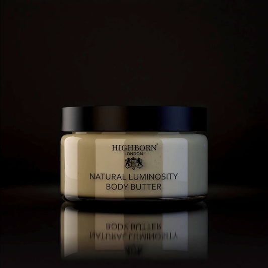 Highborn London Natural Luminosity Body Butter jar with black lid on reflective black surface