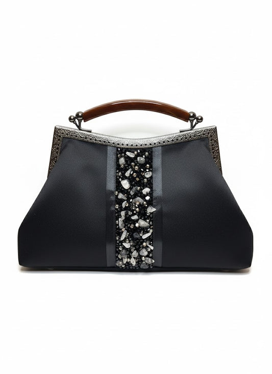 Elegant black handbag with wooden handle and decorative stone embellishments