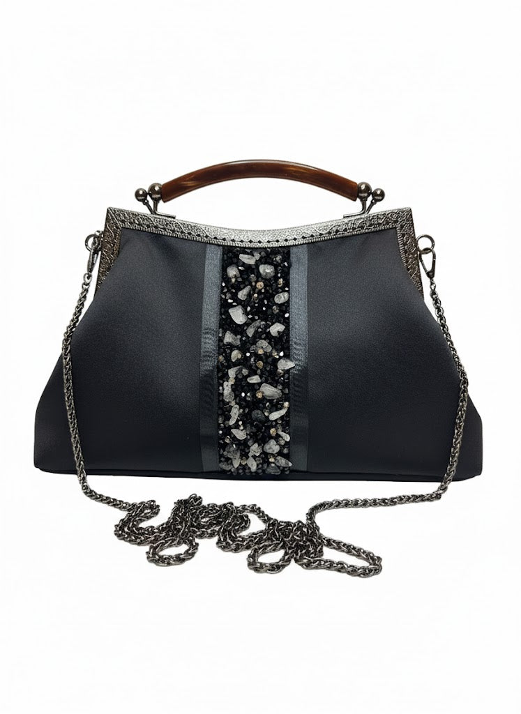 Elegant black handbag with beaded central embellishment, silver frame, wooden handle, and chain strap