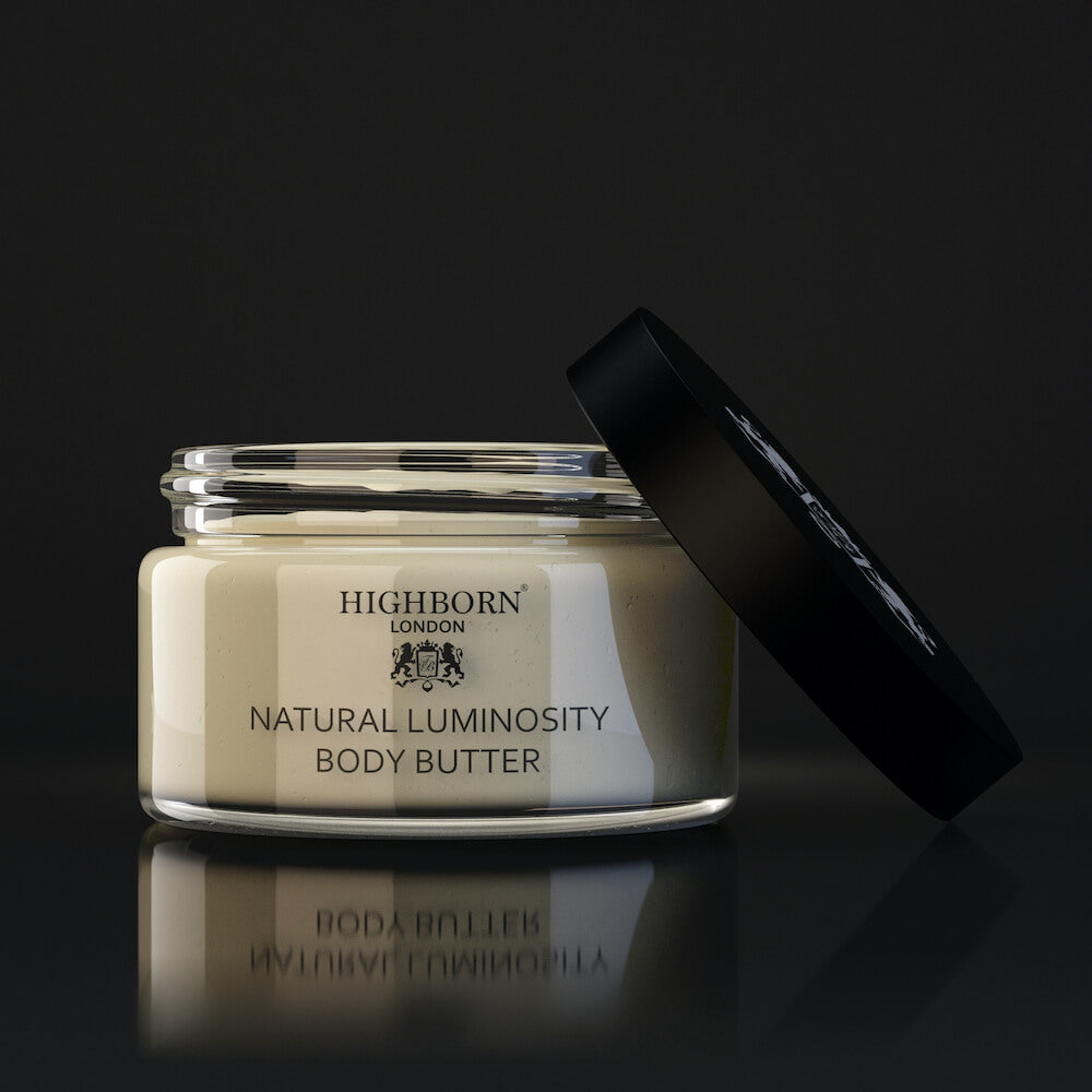 Open jar of Highborn London Natural Luminosity Body Butter with black lid on dark reflective surface